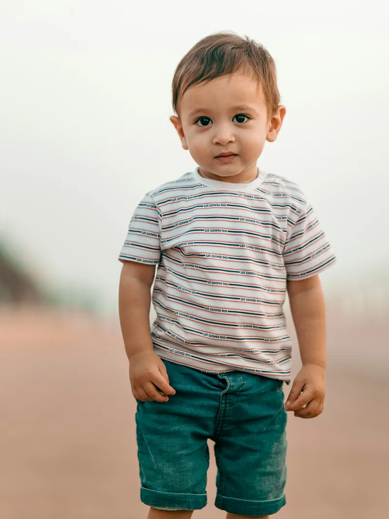 Toddler in an ecru striped cotton t-shirt and teal shorts