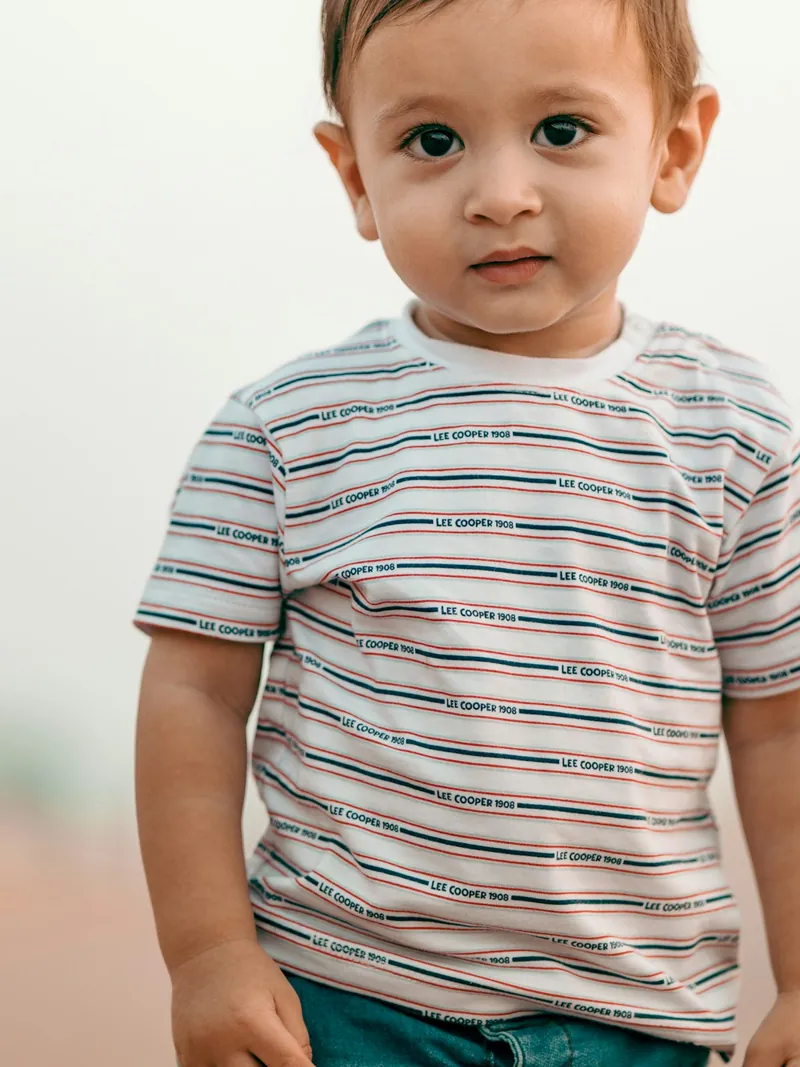 Toddler in an ecru striped cotton t-shirt and teal shorts