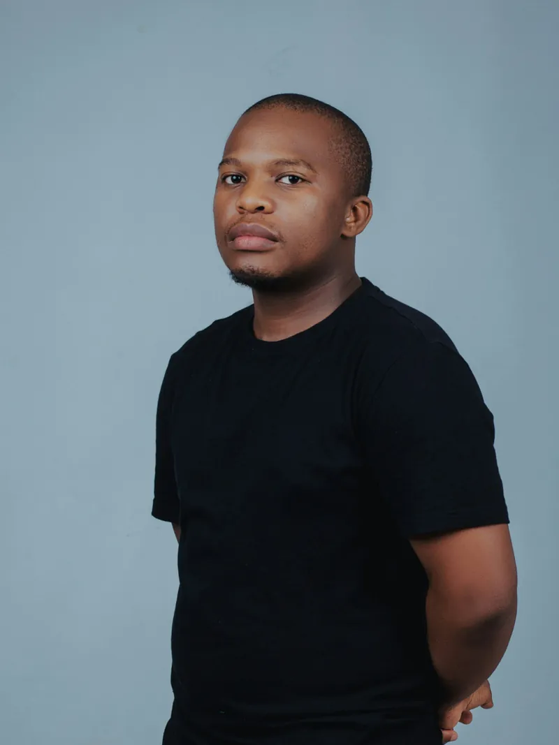 Model in a black heavyweight crew t-shirt against a blue-grey backdrop